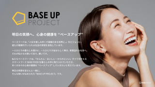 ベースフードが提唱する「BASE UP PROJECT」の紹介。健康的で笑顔溢れる社会を目指し、スマートフードBASE FOODを通じて心身の健康を向上させるというコンセプトを、笑顔の女性と共に表現
