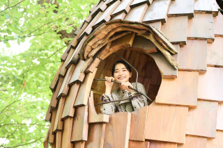 木造の建物から顔を出す見上愛さん