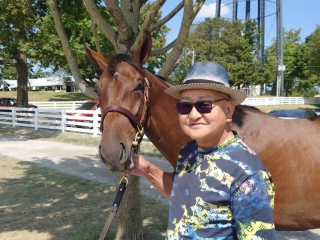 馬のそばに立つ矢作芳人調教師